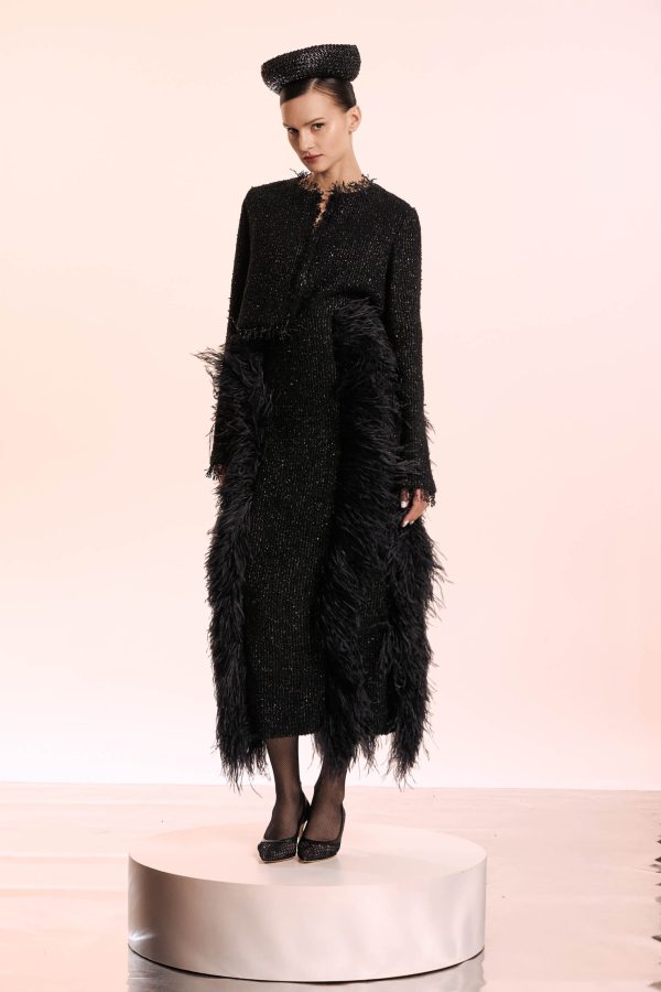 This outfit is composed of a crop blazer and a skirt that embodies the maximalist spirit. The blazer has fringed ends and its made of a soft boucle that has a silver thread inserted. The skirt is made of the same fabric and is thas luxurious feathers vertical inserted.