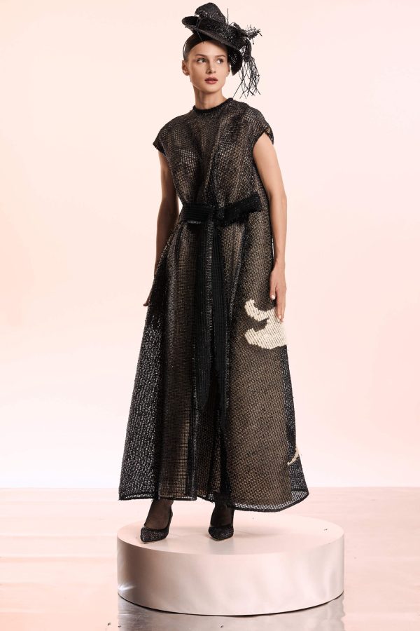 This maxi dress has an oversiez lily flower hand embroidered. It is crafted from black raffia and has a beige lining. The belt in the front can be knotted into a pretty bow at your waist.