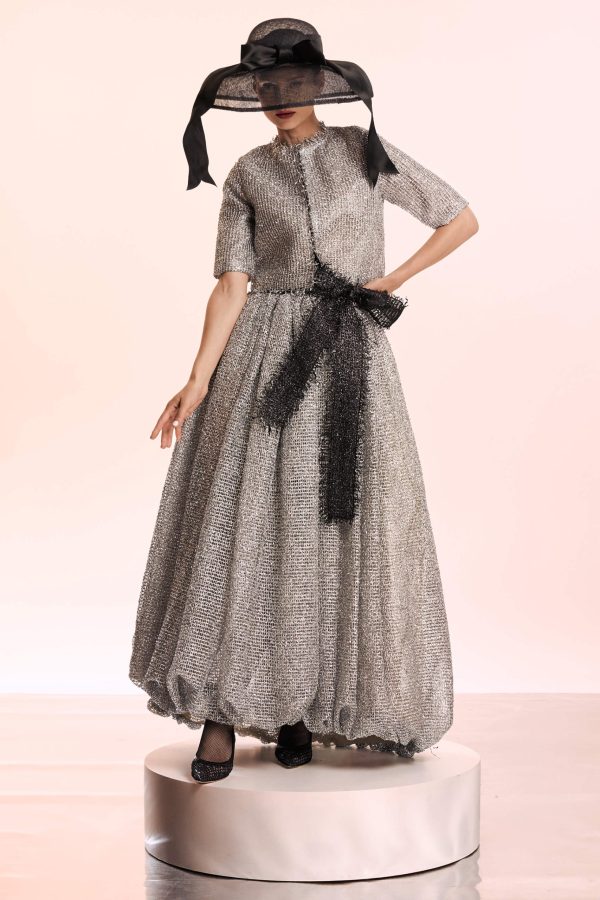 This equisite oufit is composed of a crop blazer that have a cropped profile and a voluminous skirt. The cropped length of blazer highlights its boxy proportions and works perfectly with this skirt. For obtaining this beautiful volume, the skirt is doubled with crinoline.