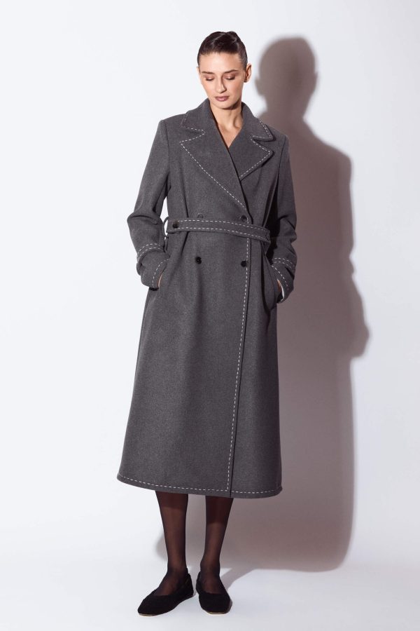 It’s a standard fit straight slightly A-lined lined coat. It's outlined by tonal chain stitches. Set-in long sleeve features two seams and a stitched pin tuck at the front seam.