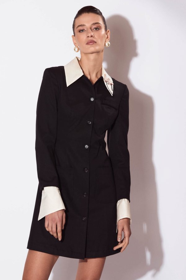 Lotus Mini Dress is a close-fitting dress with an accentuated waist. The dress has a welt above the bust on the left as well as functional patch pockets  at the hips. it has contrasting collar and cuffs and is beautifully embroidered with lotus flowers in the collar area.