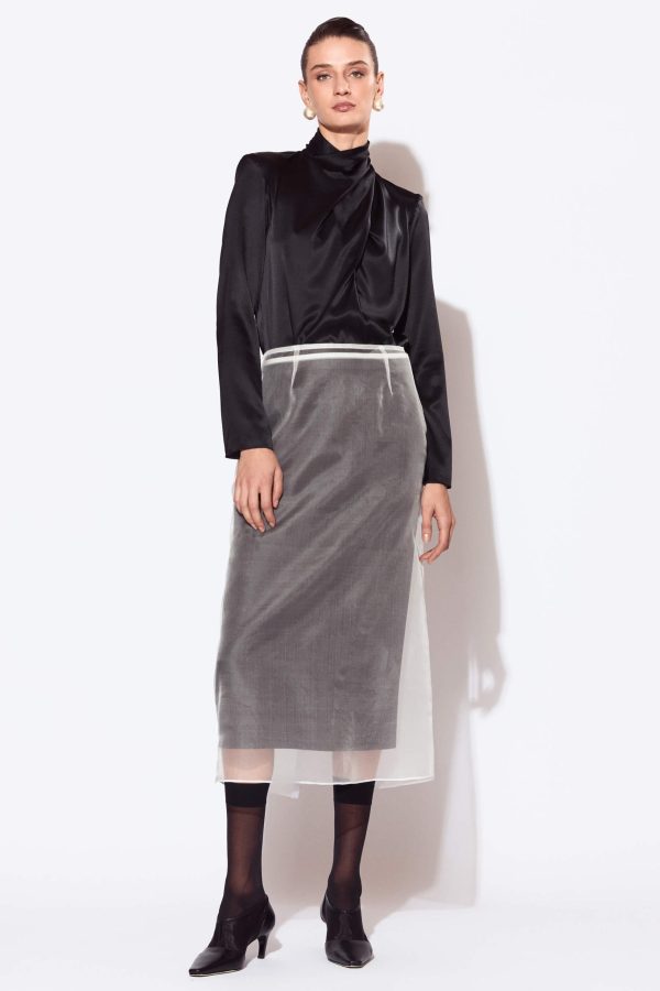 A semi-fitted, straight-cut skirt,slightly flared at the bottom. The skirt features darts both at the front and back and has no waistband. It consists of two layered skirts which can be worn separately too, thus forming a versatile piece. You can wear it as we proposed, as a classic black skirt or as a refined silk organza skirt.