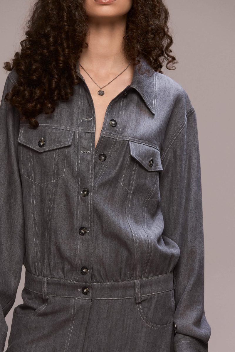 This gray demin boilersuit is a long-sleeved, full-length garment with a straight leg cut, has a front closure with buttons and zipper for the trousers. It features patch pockets on both sides of the chest and 4 functional ones, two in front and other two on the back of the trousers. Its fit is comfortable yet flattering, making it a versatile wardrobe piece. Wear it on it's own or with a contrasting belt.