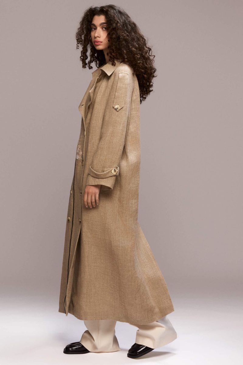 This long beige coat is made of 100% and it features a handmade lotus flowers. It also has a detachable belt.