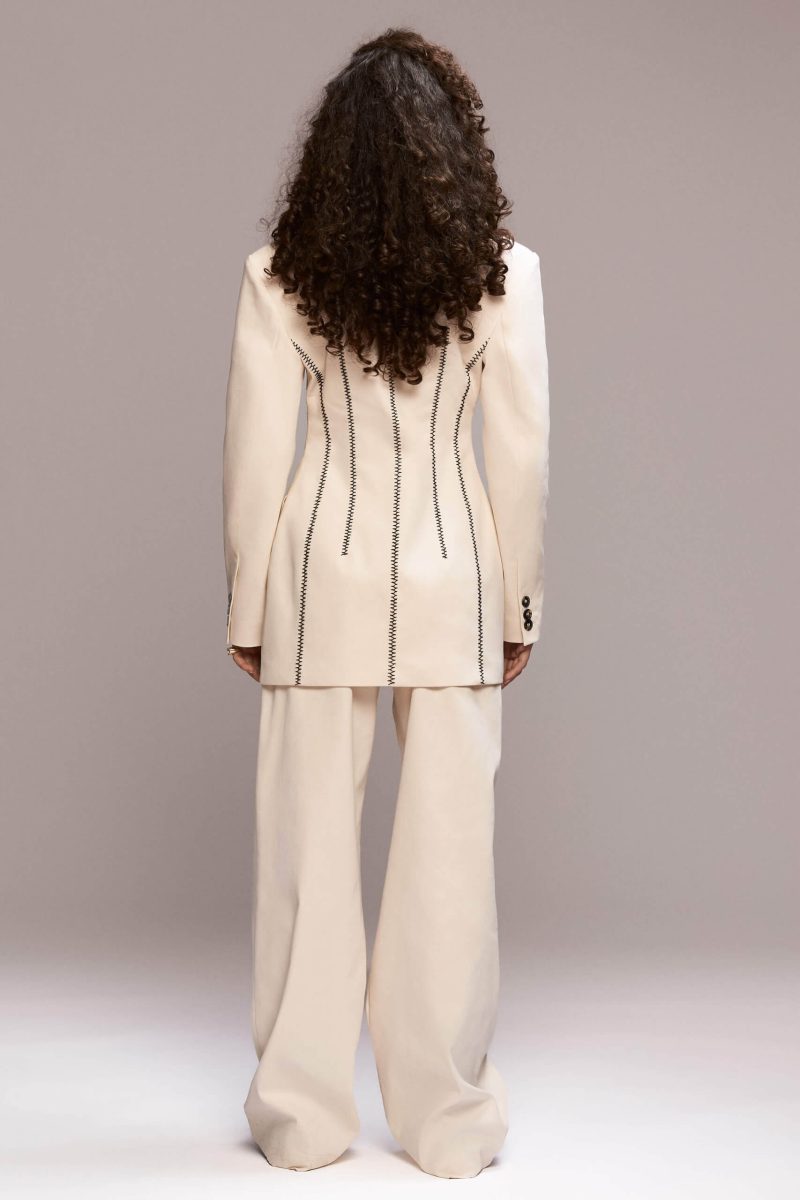 This hand stiched blazer has a timeless, elegant cut with a slightly structured, straight silhouette. It features hand stiches, a