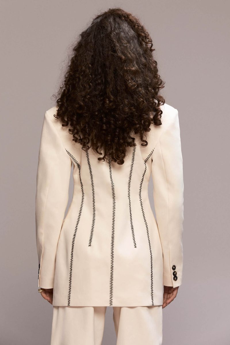 single-button front closure, padded shoulders and functional pockets. It can be worn with a matching trousers for a total look.