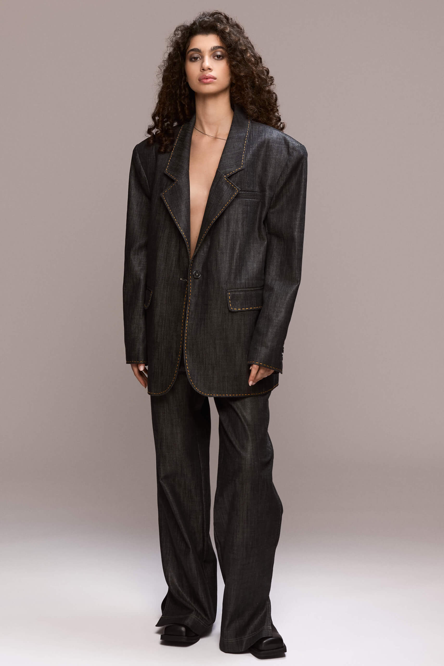 This distinctive blazer has a timeless, elegant cut with a slightly structured, straight silhouette. It features contrasting hand-stiched seams along the lapels, pockets and side seams, a single-button front closure, padded shoulders and functional pockets. It can be worn with our matching trousers for a total modern and bold look.