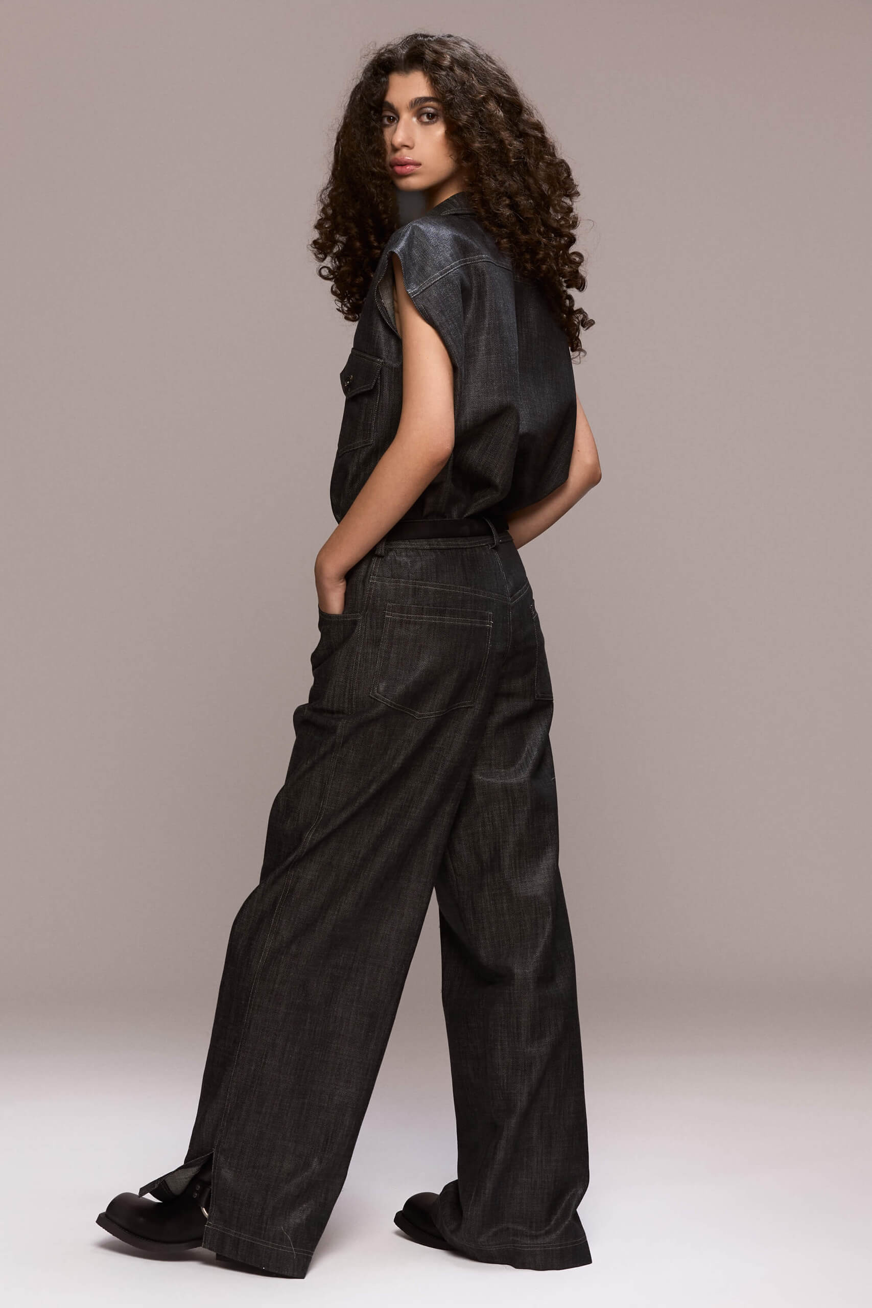 These black wide-leg trousers feature front pleats, which give them a comfortable and flowy fit. They are full length, with front pockets and one single back pocket on the right side. There is a fly front zipper closure. Wear them with our matching black sleeveless shirt for a total look.