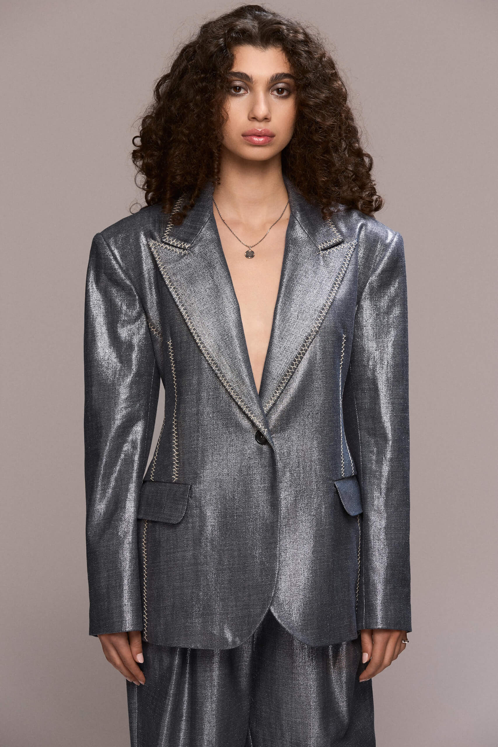 This distinctive blazer has a timeless, elegant cut with a slightly structured, straight silhouette. It features contrasting hand-stiched seams along the lapels, pockets and side seams, a single-button front closure, padded shoulders and functional pockets. It can be worn with our matching trousers for a total modern and bold look.