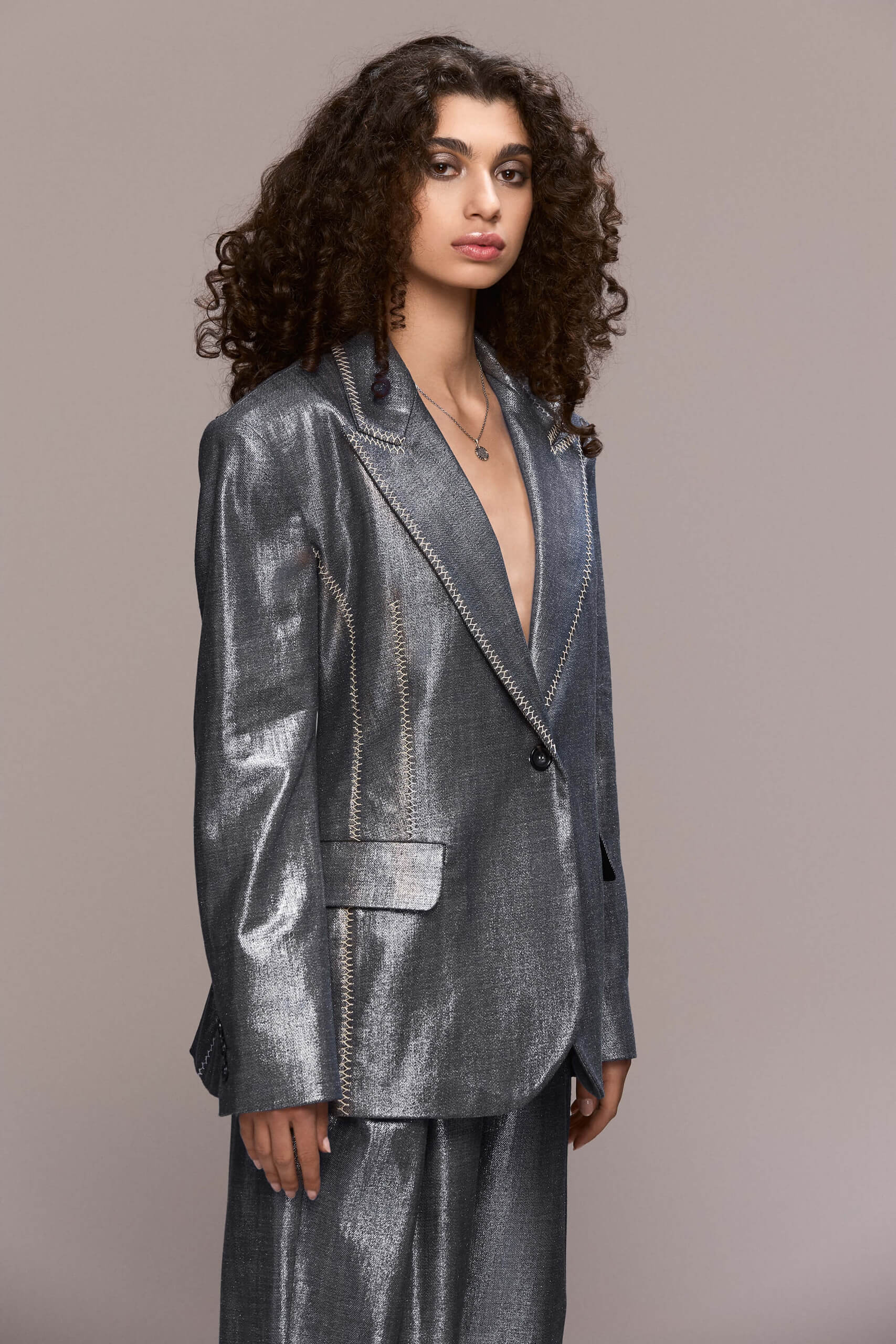 This distinctive blazer has a timeless, elegant cut with a slightly structured, straight silhouette. It features contrasting hand-stiched seams along the lapels, pockets and side seams, a single-button front closure, padded shoulders and functional pockets. It can be worn with our matching trousers for a total modern and bold look.