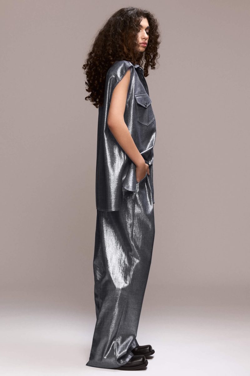 A sleveless, oversized button-down shirt featuring a collared neckline and dual chest pockets, this piece gives a distinctly modern and eye-catching appearance. Wear it with our matching wide leg trousers for a full statement look.