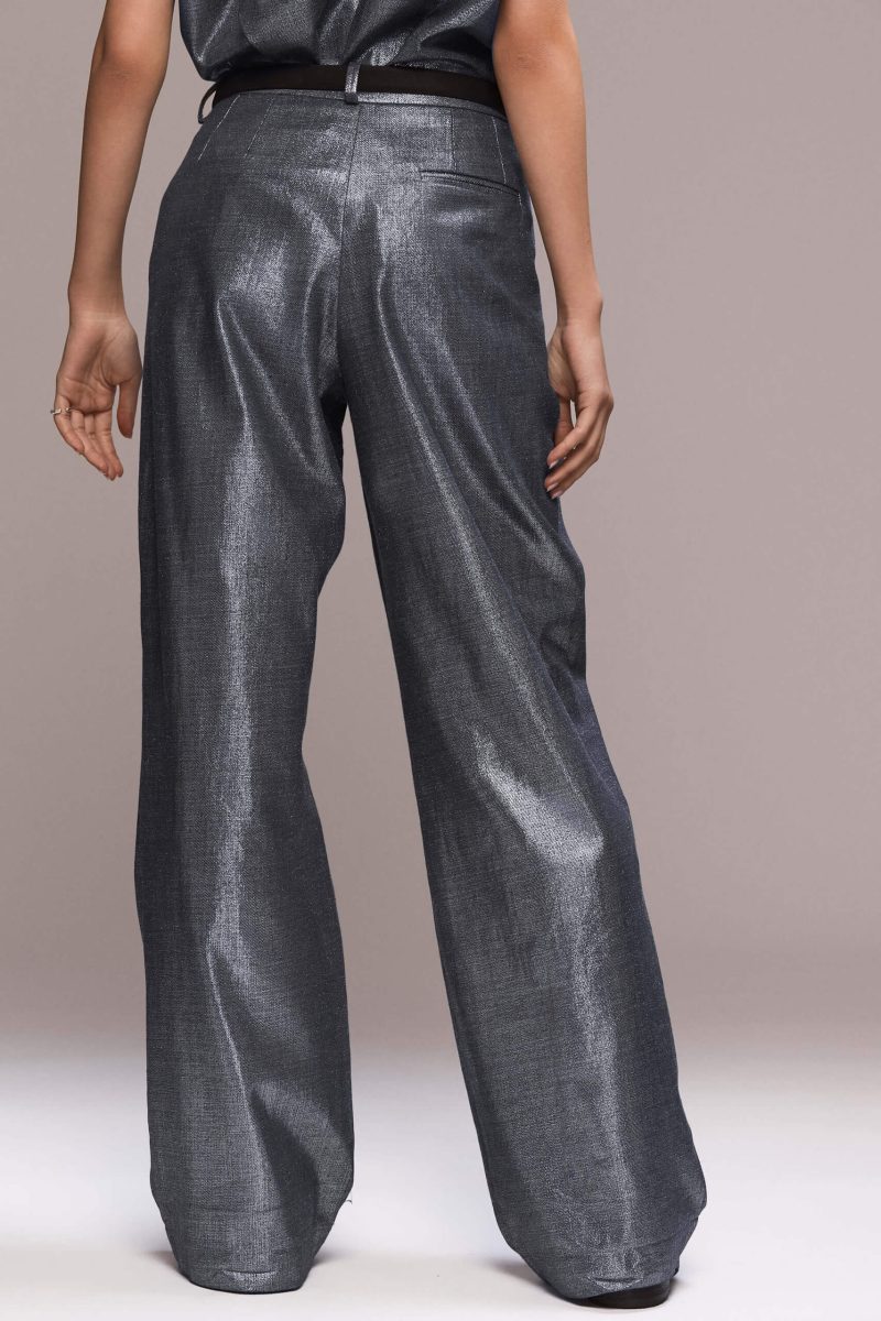 These metallic wide-leg trousers feature front pleats, which give them a comfortable and flowy fit. They are full length, with front pockets and one single back pocket on the right side. There is a fly front zipper closure. Wear them with our matching metallic sleeveless shirt for making a bold statement, at glamorous events or day dates.