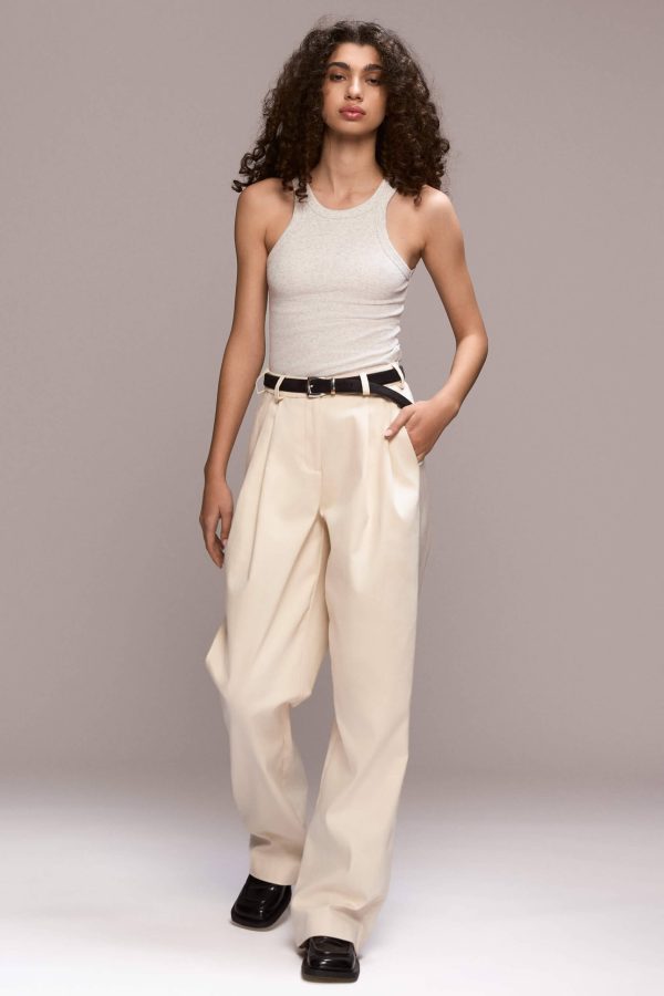 These wide-leg ivory trousers feature front pleats, which give them a relaxed silhouette. They have full length, front pockets and one single back pocket on the right side. There is a fly front zipper closure.