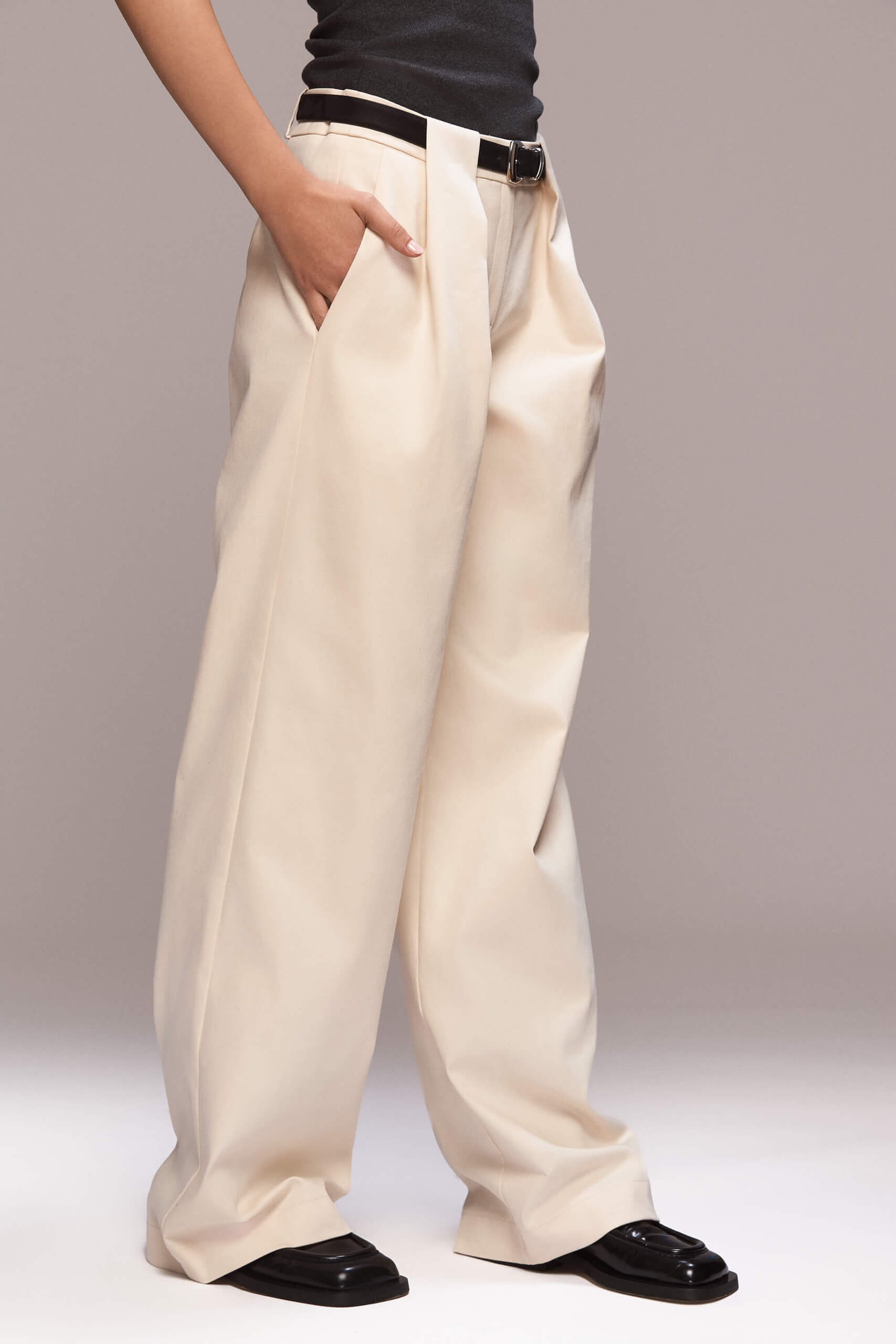 These wide-leg trousers have a loose fit, with functional side pockets, and a single back pocket on the right side. The trousers features belt loops, the two distinct front ones create pleats that contribute to a relaxed fit and a beautiful design detail.