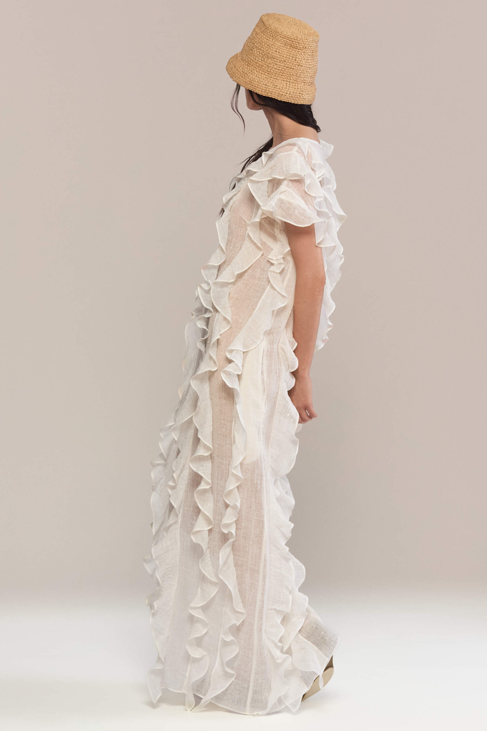 The frilled maxi dress has a loose fit, with a sleeveless design and a round neckline. It features layered ruffles on both the front and back giving it a fluid and feminine look. It is the perfect choice for summer events, or a bohemian-inspired look.