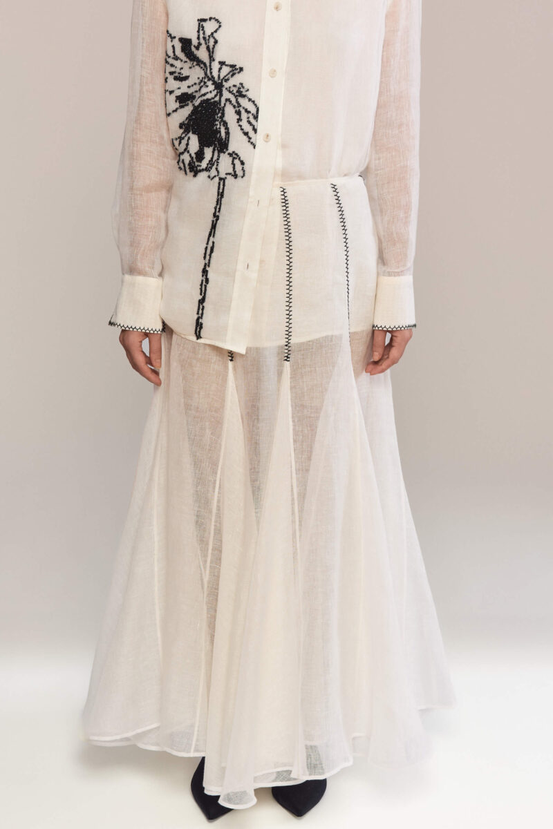The maxi skirt with a loose, voluminous hem that combines a minimalist design with hand-stitched vertical details, adding a handcrafted touch. Perfect to pair with our matching shirts for a bold and sophisticated look.