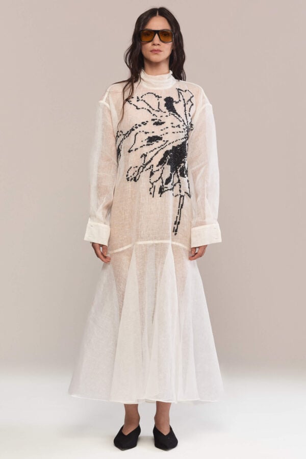 Refinement and comfort in one dress: the high neckline and loose fit combine with the handmade black floral embroidery, creating the perfect outfit for a chic daytime look or an elegant evening appearance.