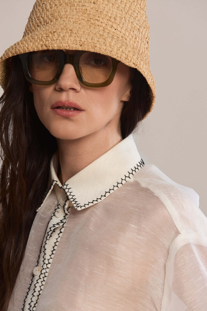 This oversized, semi-sheer shirt features a relaxed fit with long sleeves and a classic pointed collar. Black contrast hand stitch embroidery highlights the collar, front placket, and cuffs, creating a subtle, handcrafted minimalist aesthetic. Wear them with our classic black trousers for a total look.