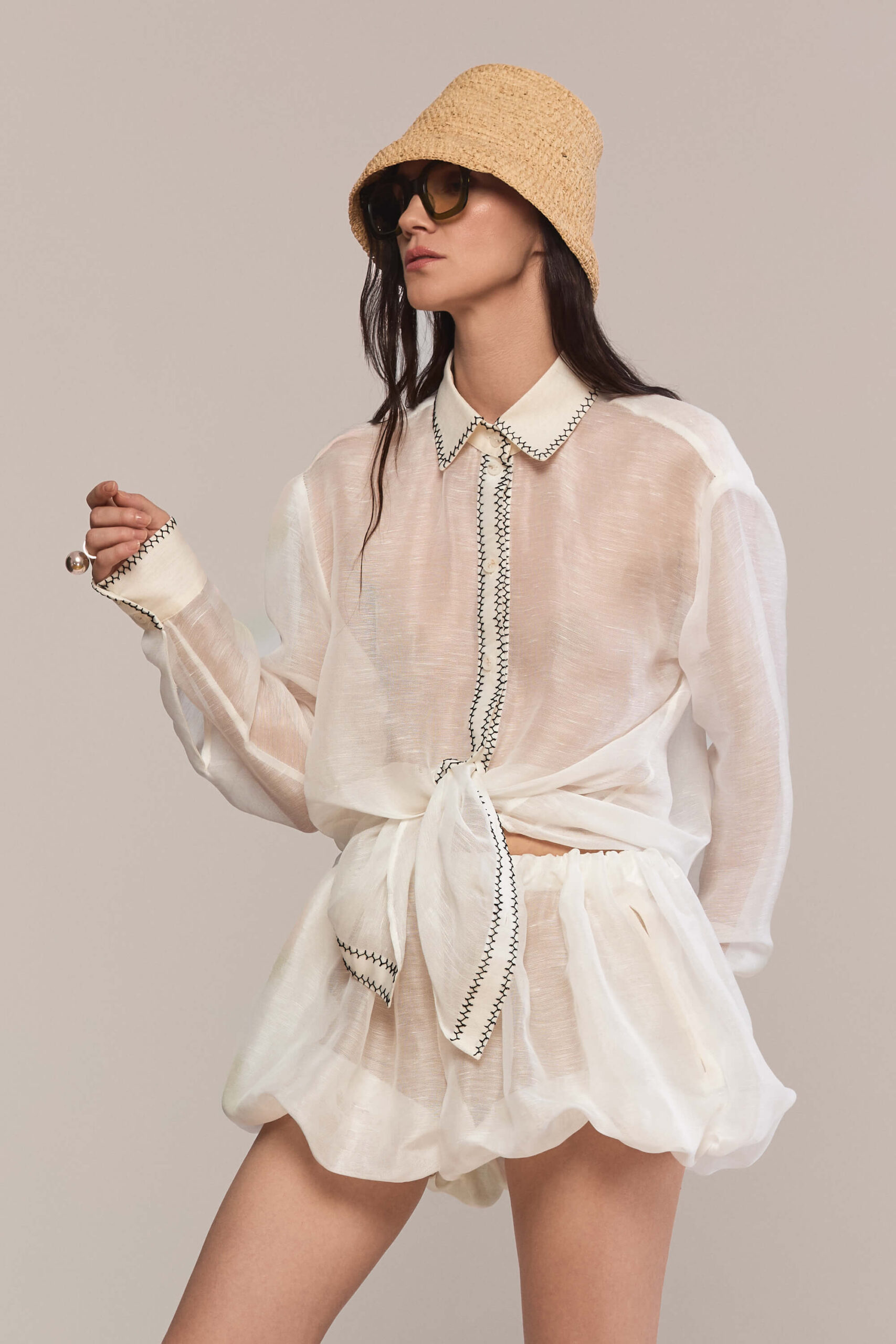 This oversized, semi-sheer shirt features a relaxed fit with long sleeves and a classic pointed collar. Black contrast hand stitch embroidery highlights the collar, front placket, and cuffs, creating a subtle, handcrafted minimalist aesthetic. Wear them with our classic black trousers for a total look.